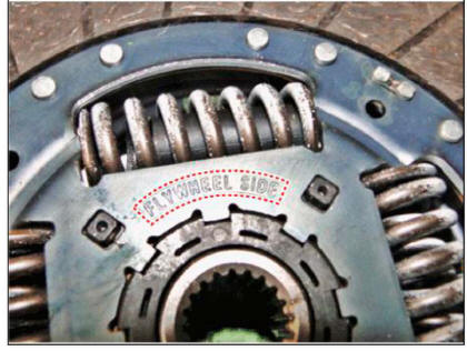 The 'FLYWHELL SIDE' marked surface should face the flywheel.